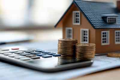 Kleines Häuschen mit Taschenrechner und Münzen - © VINA - stock.adobe.com