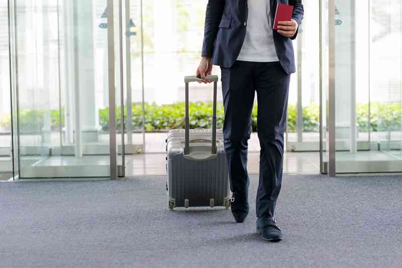 Mann mit Koffer am Flughafen